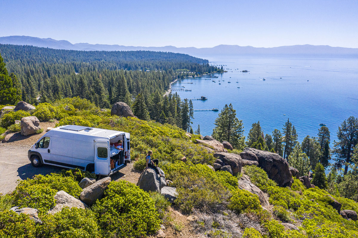 Young couple enjoying the view of lake from motorhome